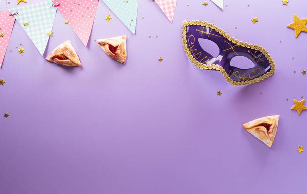 Happy Purim karneval dekorace koncept vyrobený z masky a jiskřivé hvězdy a hamantaschen cookies na pastelovém pozadí. (Happy Purim v hebrejštině, židovské svátky slaví) - Fotografie, Obrázek