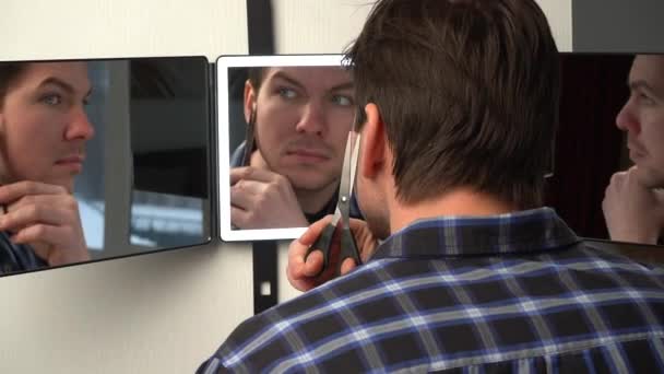 ドアには男が鏡を掛けている。男は現代のスマートミラーの前で彼の美しさを披露します。バックライト付きスマートミラー - 映像、動画