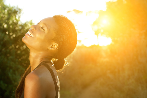 Sonriente afroamericana mujer deportiva de pie al aire libre
 - Foto, imagen