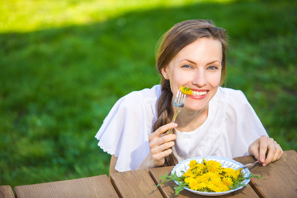Funny woman eating dandelion diet salad - Foto, Imagen