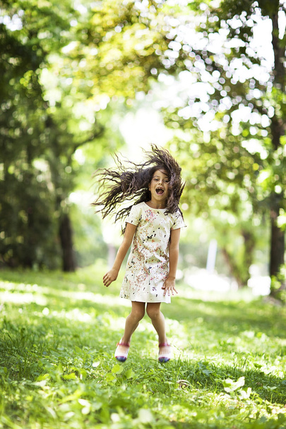 Krásná dívka, která skočila, usmíval se v parku - Fotografie, Obrázek