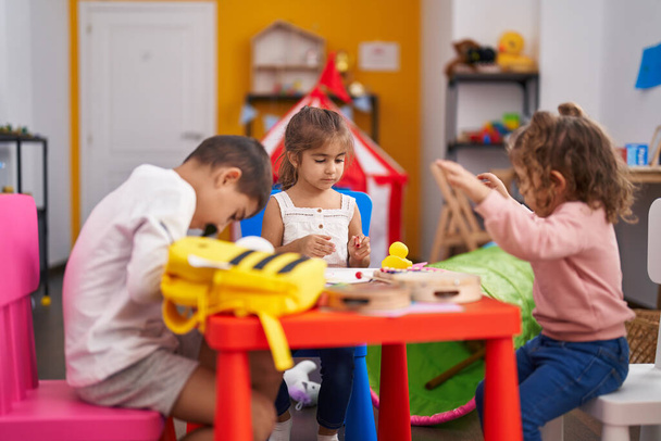 Grupo de niños estudiantes de preescolar sentados en un dibujo de mesa sobre papel en el jardín de infantes - Foto, Imagen