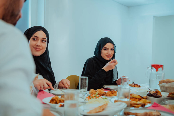 Мусульманська сім'я вечеряє іфтаром, п'ючи воду, щоб розірвати бенкет. Їсти традиційну їжу під час рамадійського бенкету вдома. Ісламська халяль їсть і п "є в сучасному домі. - Фото, зображення