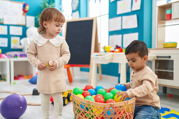 Zwei Kinder spielen im Kindergarten mit Bällen - Foto, Bild