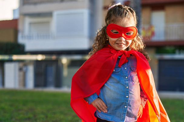 Adorabile bionda bambino sorridente fiducioso indossando costume supereroe al parco - Foto, immagini