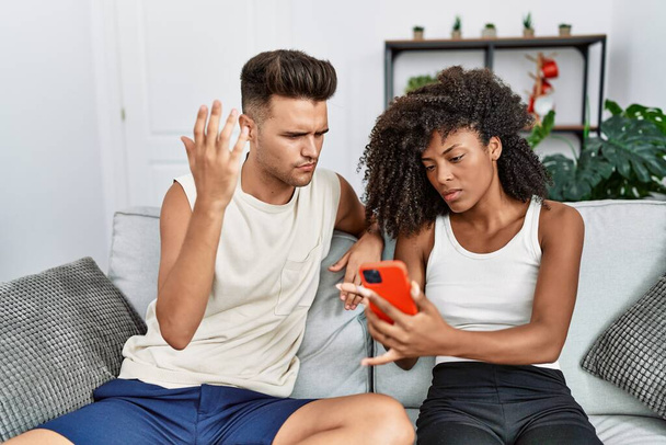 Man en vrouw paar met problemen met het gebruik van smartphone thuis - Foto, afbeelding