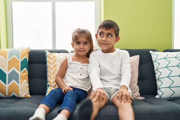 Brother and sister smiling confident sitting on sofa at home - Foto, imagen