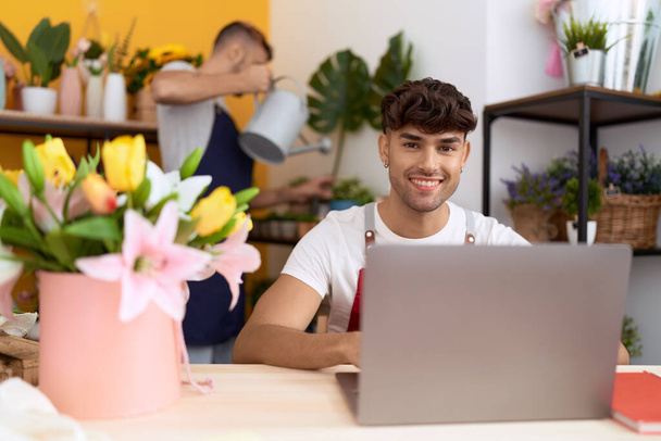 Kaksi latino miehet kukkakaupat käyttävät laptop kastelu kasvi kukkakauppa - Valokuva, kuva