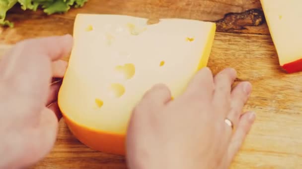 La donna tiene in mano un pezzo di formaggio con dei buchi. Slider filmato formaggio processo di presentazione. - Filmati, video