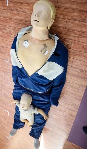 Human dummy lies on the floor during first Aid Training - Cardiopulmonary resuscitation. First aid course on CPR dummy, CPR First Aid Training Concepts - Foto, Imagen