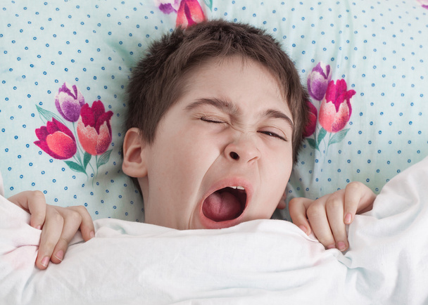 Boy lying awake in bed - Foto, Imagen