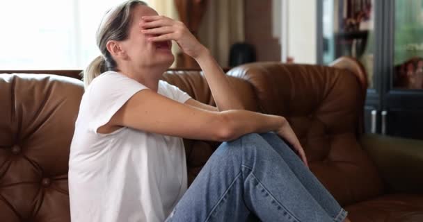 Una mujer sentada en el sofá está llorando amargamente, un primer plano, una cámara lenta. Concepto sufrimiento emocional, dolor - Metraje, vídeo