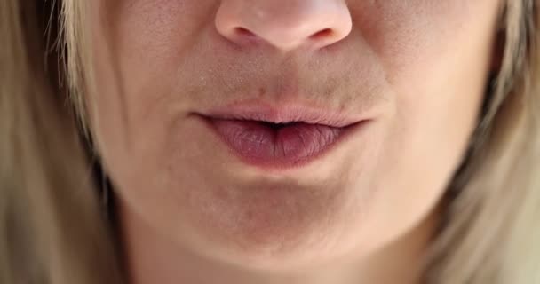 Een vrouw steekt een vinger naar haar lippen, een close-up gezicht. Het concept is non-verbale communicatie, stilte, samenzwering - Video