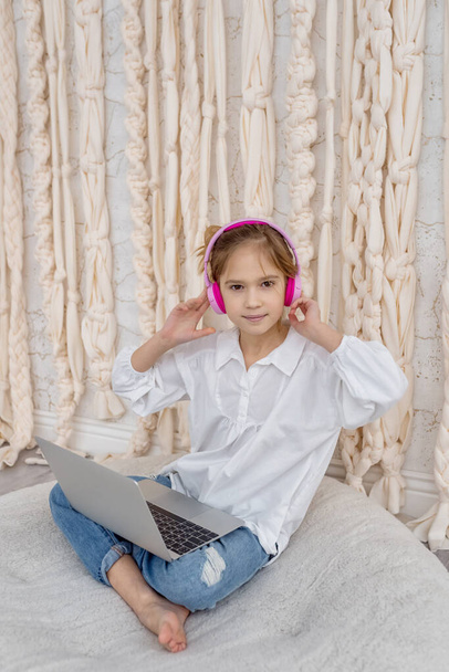 Caucasian teen girl school pupil in headphones studying online from home. Remote education concept. Teenage student distance learning on laptop, doing homework, watching, listening video lesson - Foto, Imagem