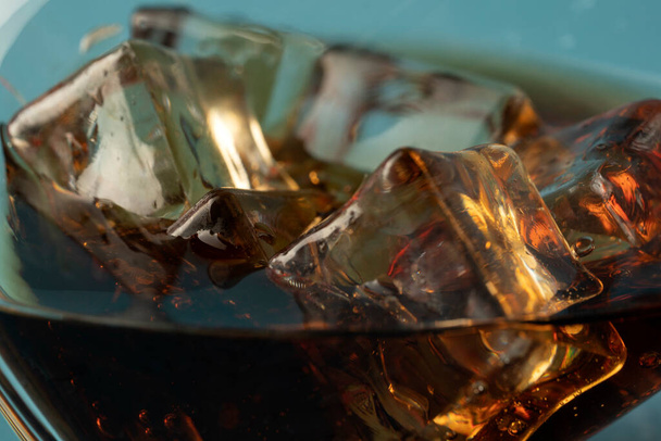 Coke or club soda poured into a glass with ice cubes - Foto, imagen