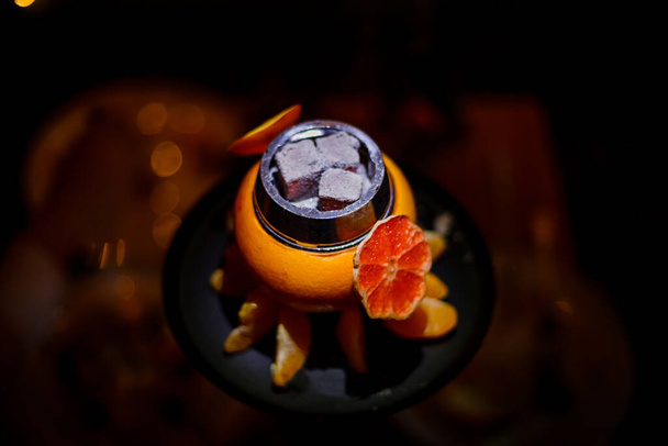 Hookah on orange with smoke, with tangerine slices . High quality photo. Close-up photo - Φωτογραφία, εικόνα