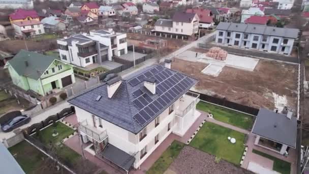 Aerial drone video of residential district with houses, buildings, streets and homes with photovoltaic solar panels. Modern houses with renewable sources of energy in suburban neighborhood. - Πλάνα, βίντεο