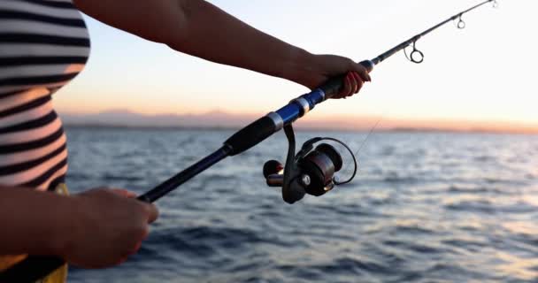 日没時の女性は釣竿で魚をキャッチ,クローズアップ,スローモーション.自然の美しい景色,趣味 - 映像、動画