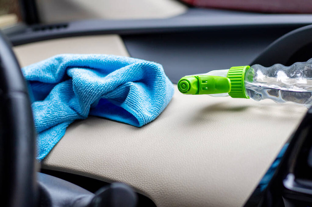 car wash and interior chemical cleaning concept.hand use microfiber cloth and spray to clean lateral door from inside,retractable rear view mirror,steering wheel.modern hybrid vehicle clean inside - Foto, imagen