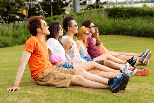Jóvenes sentados en la hierba
 - Foto, imagen