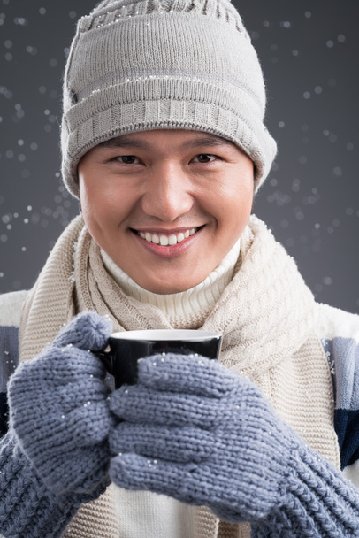Mies talvivaatteissa tilalla kuppi teetä
 - Valokuva, kuva