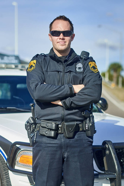 Безпека це моя проблема номер один. Повнометражний портрет красивого молодого поліцейського, який стоїть з руками, схрещеними під час патрулювання
 - Фото, зображення