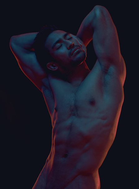 Naked, art and freedom with a model asian man in studio on a dark background for artistic body positivity. Skin, natural and artwork with a handsome young male posing nude on a black backdrop. - Photo, Image