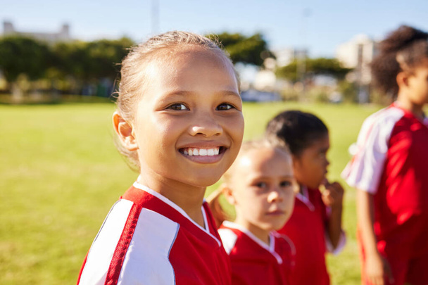 Girl soccer player, portrait and field for training, teamwork and group diversity with smile. Young female kids, football group and happy for team building, learning and development with excited face. - Photo, image