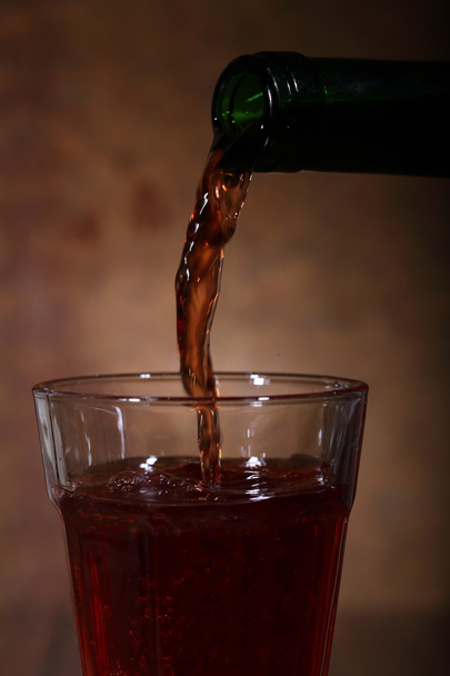 Wine flows from a bottle in a glass - Foto, Imagen