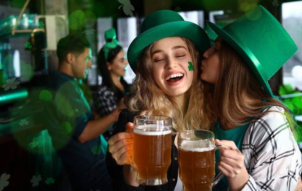 Young women with beer celebrating St. Patrick's Day in pub - Zdjęcie, obraz