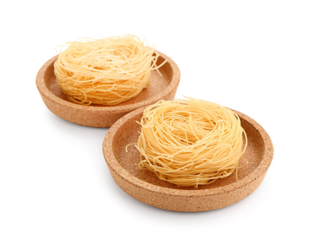 Plates of raw pasta nests on white background - Photo, Image