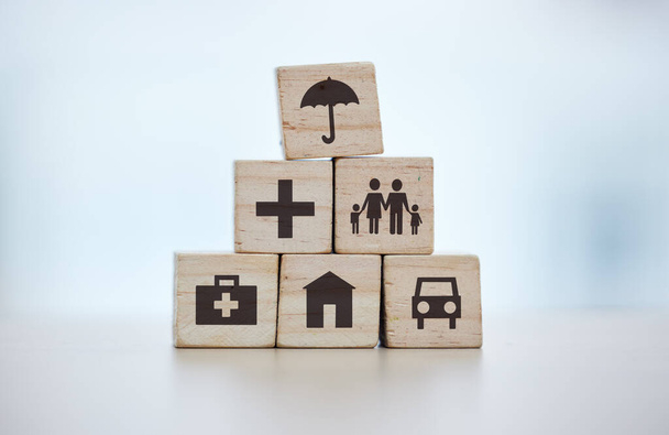 Building blocks, pyramid and life insurance for medical, car loan or home on background mockup, table or desk mock up. Zoom, wooden and cubes for house risk management, security and future protection. - Fotoğraf, Görsel