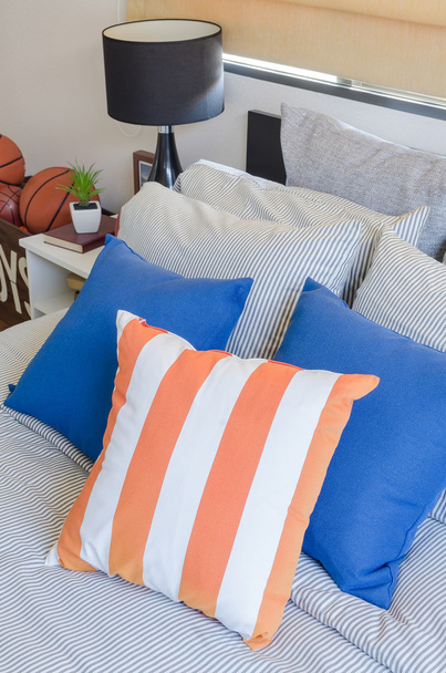 almohadas naranja y azul en la cama
  - Foto, Imagen