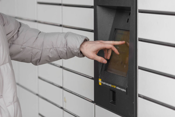 Pniewy, Poland - 22 January 2023. Shopping locker inPost with mans hand entering code to open it. E-commerce shipping and delivery concept. - Foto, Imagem