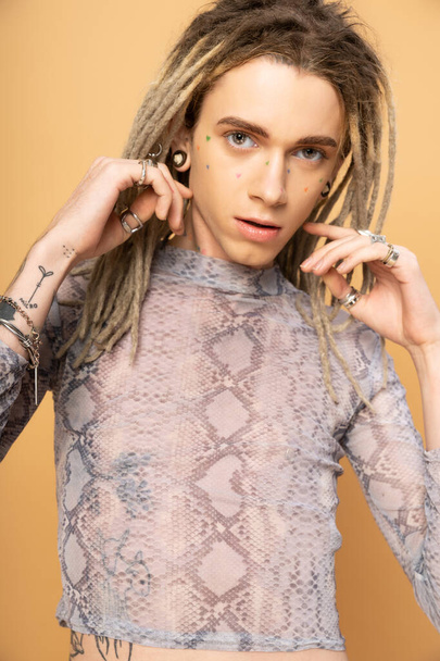 Portrait of tattooed queer person with dreadlocks looking at camera isolated on yellow  - Fotoğraf, Görsel