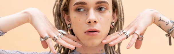 Nonbinary person with dreadlocks and rings on fingers isolated on yellow, banner  - Foto, immagini
