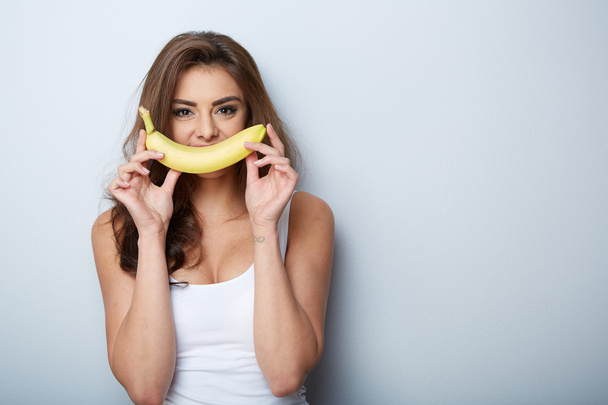 woman making fun with a banana - Foto, afbeelding