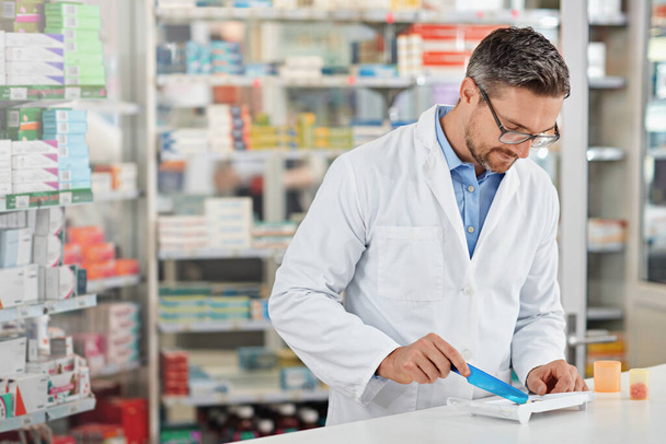 Pharmacist man, store and counting with pills, medicine and focus for health, product or sales. Medical professional, pharma expert or sorting medication in pharmacy for wellness, healthcare and job. - Photo, image
