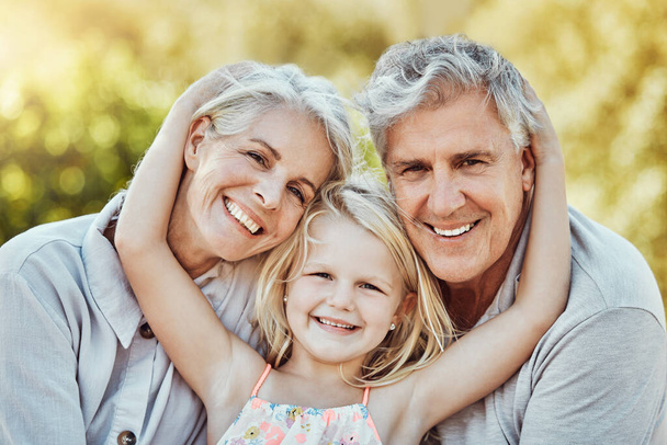Grandparents, park and child hug portrait with a young girl and elderly people with love and smile. Care, bonding together and nature of a family feeling happy with kid and elderly grandparent. - Fotoğraf, Görsel