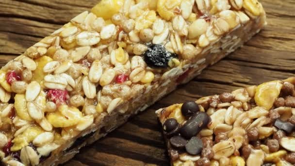 Cereal superfood energy bars with almond nuts, dry fruits, raisins chocolate on the wood table - Séquence, vidéo