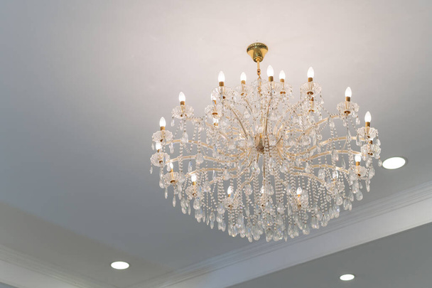 Luxury beautiful crystal chandelier in exhibition hall. - Fotó, kép