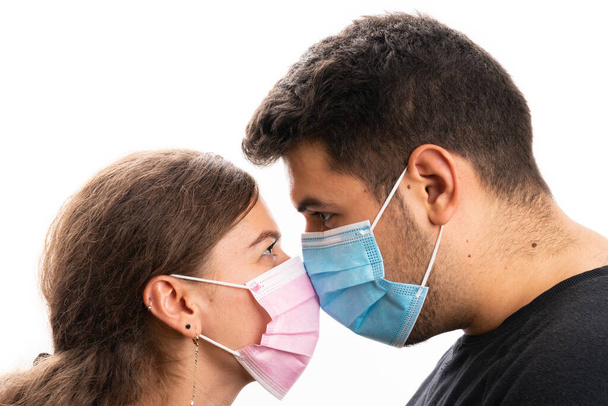 Close-up of female male couple wearing pink and blue medical or surgical protective dace masks to prevent infection with sars covid19 virus isolated on white background - Foto, Bild