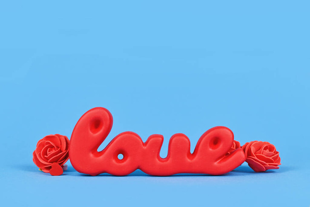 Valentine's Day decoration with red word love on blue background - Valokuva, kuva