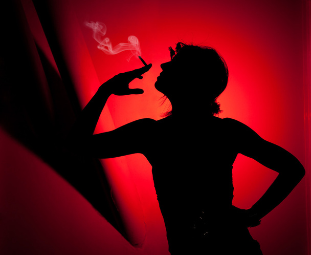 Silueta de mujer fumando
 - Foto, Imagen
