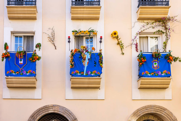 Beautifully decorated balconies in the Plaza de San Pedro in the city of Huelva, on the occasion of the procession of the patron saint of the city, San Sebastian - Zdjęcie, obraz