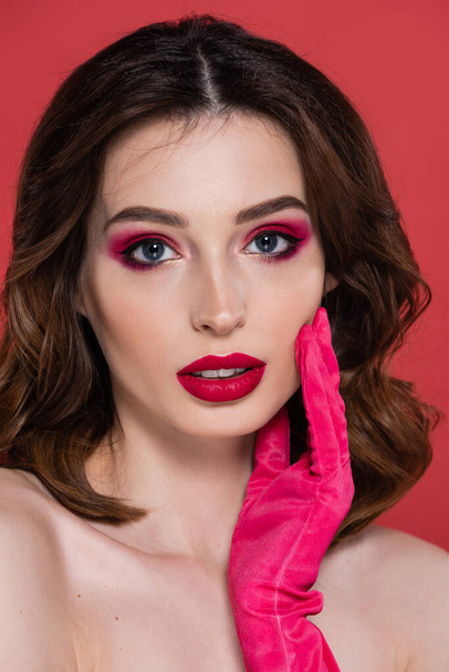portrait of pretty woman with magenta color eye shadow isolated on pink  - Foto, immagini