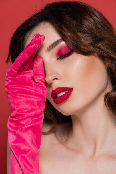 portrait of young woman with magenta color eye makeup and closed eyes isolated on pink  - Fotoğraf, Görsel