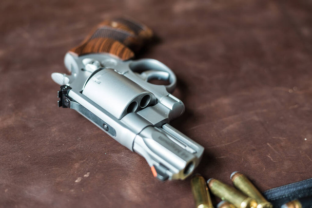 .44 magnum revolver gun with bullet on leather background personal defence - Foto, Bild