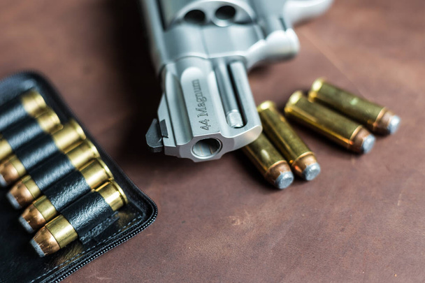 .44 пистолета-револьвера магнума с пулей на кожаном фоне - Фото, изображение