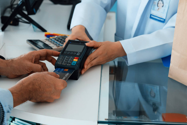 Payment by credit card with payment terminal in qualified drugstore or hospital. Modern payment of electric money. Closeup customer purchase medication in pharmacy with credit card on pos. - Foto, Bild